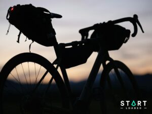 Silhouette of a touring bike loaded with bikepacking bags at sunset