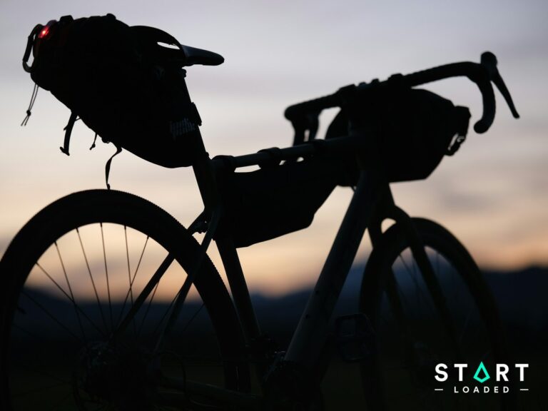 Silhouette of a touring bike loaded with bikepacking bags at sunset