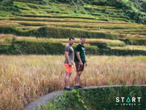 Two friends standing on a path through rice terraces