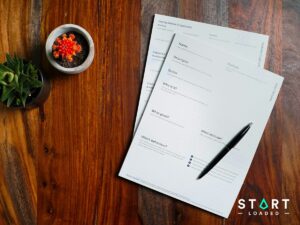 Wooden table with printed documents and a pen
