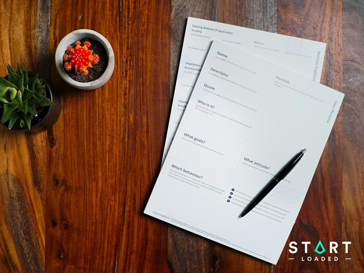 Wooden table with printed documents and a pen