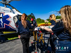 Medical crew loading a stretcher into an air ambulance helicopter