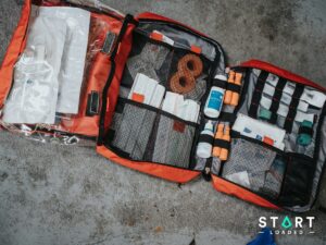 Open red first aid bag packed with medical supplies