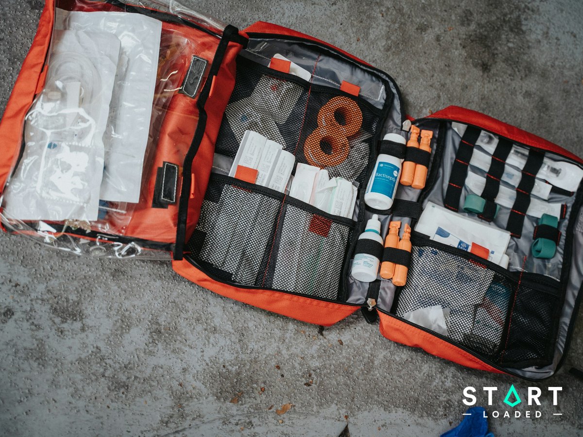 Open red first aid bag packed with medical supplies