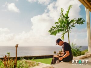 Man sitting on a terrace overlooking the ocean in the tropics