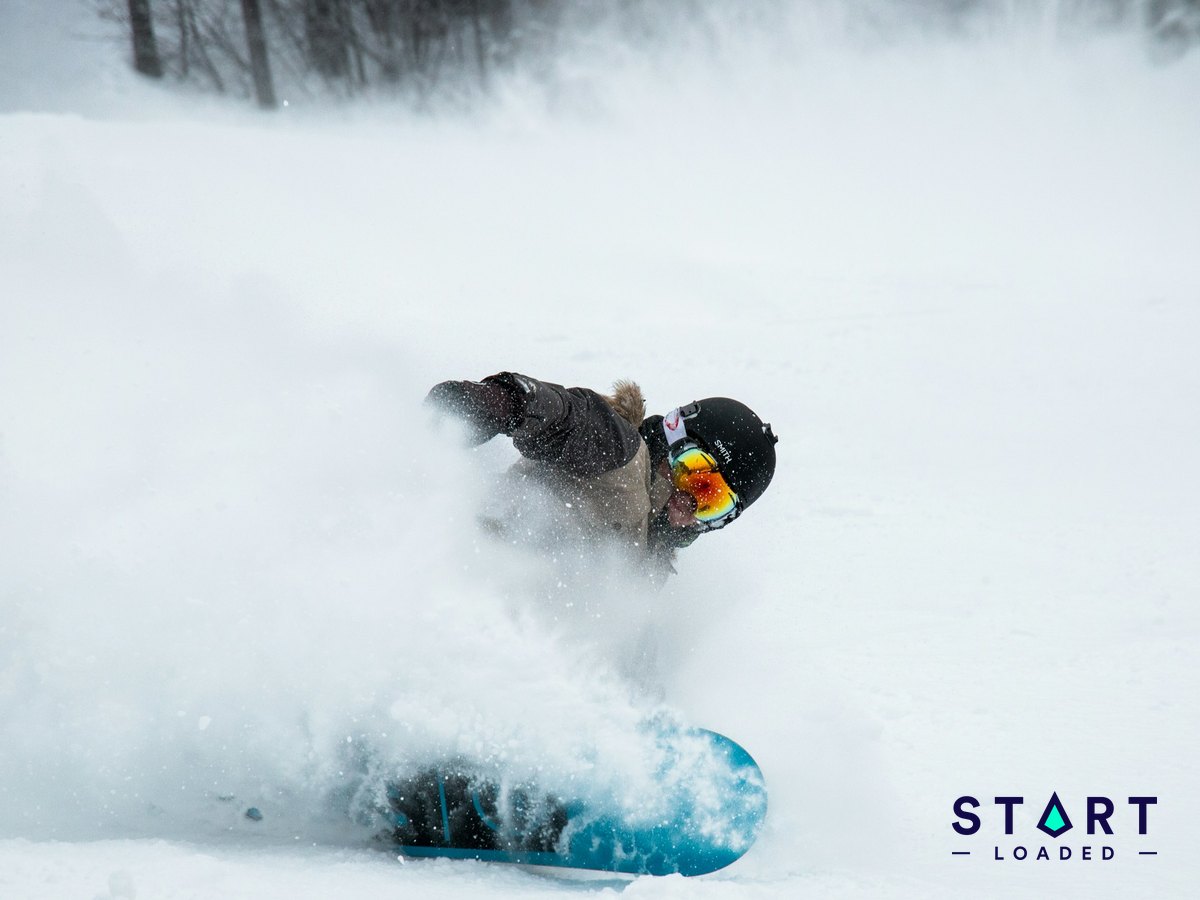 Snowboarder carving through fresh snow