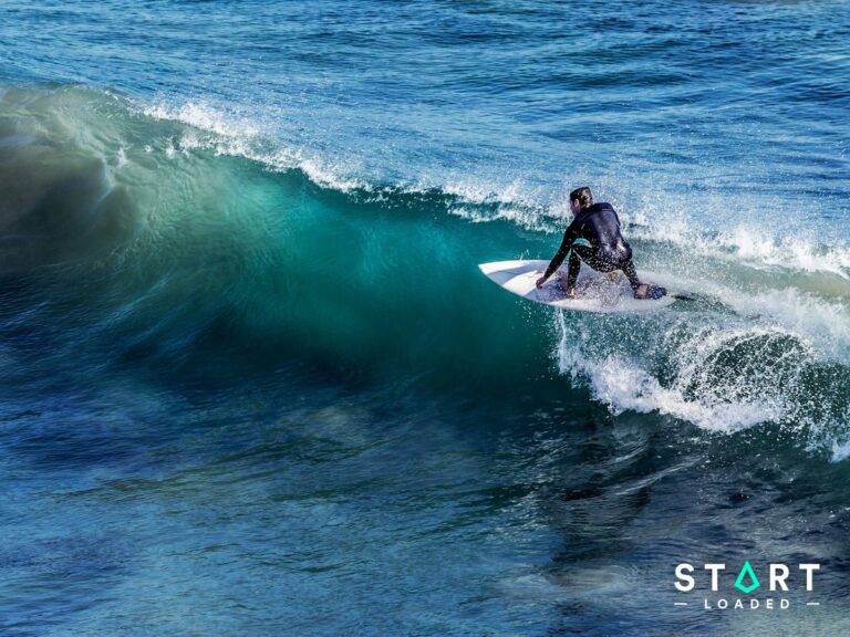 Surfer riding a breaking turquoise wave